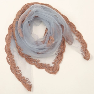 Close-up of elegant blue-grey sheer fabric with intricate brown lace embroidery