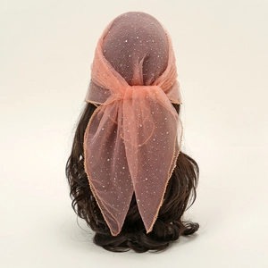 Coral pink mesh headscarf with silver rhinestones and gold wavy edges on dark curly hair