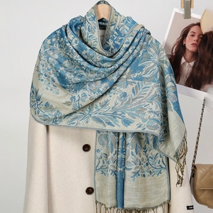 Détail d'une écharpe à pompons vintage avec motif floral et étiquette fait main