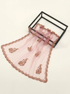 Detailed embroidery of paisley patterns and lace on dusty pink sheer tulle fabric