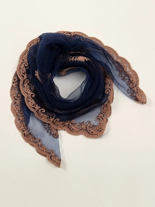 Detail of navy blue mesh scarf featuring elegant bronze floral lace embroidery trim