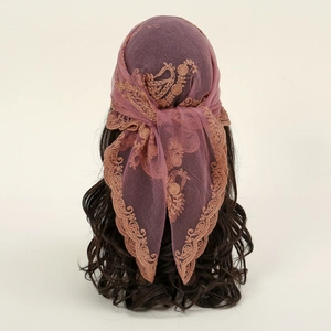 Detail of elegant smoky pink lace headscarf with delicate floral embroidery and scalloped edges