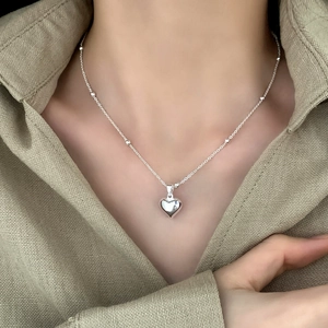 Minimalist heart pendant necklace with beaded chain worn on neck for a daily elegant look