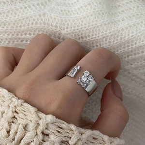 Silver wide open ring with rectangular and round cubic zirconia on hand in soft light