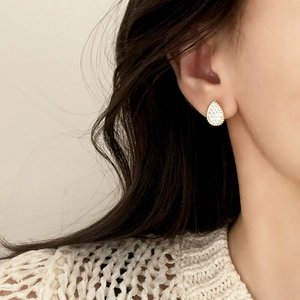 Elegant gold-tone teardrop earrings with shimmering cubic zirconia and milgrain edges