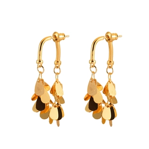 Boucles d'oreilles pendantes dorées avec pampilles de feuilles sur fond blanc