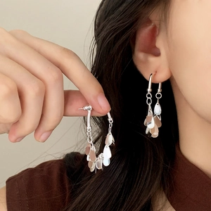 Boucles d'oreilles pampilles argentées avec sequins polis portées par un mannequin