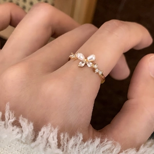 Elegant gold butterfly open ring featuring pearl wings and cubic zirconia accents on hand