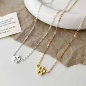 Detailed view of 3D floral necklaces in gold and silver finish with zircon centerpiece