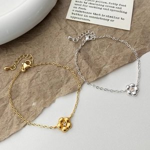 Détail de bracelets fleur délicats en or et argent avec fermoir mousqueton robuste
