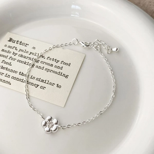 Détail macro d'un bracelet floral en argent avec pendentif à cinq pétales et fermoir