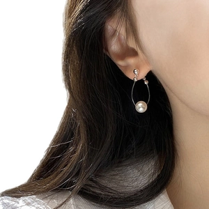 Elegant drop earrings featuring a teardrop silver frame and a round white pearl on model