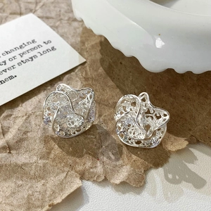 French style silver hollow lace earrings with sparkling cubic zirconia on textured paper