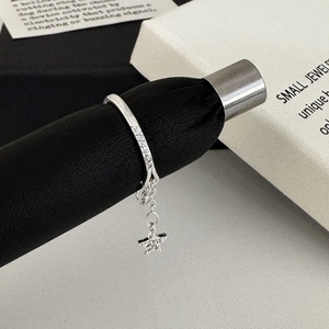 Macro detail of silver star pendant ring with pave cubic zirconia and dangling chain