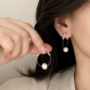 Boucles d'oreilles créoles minimalistes en argent avec perle sur un mannequin femme