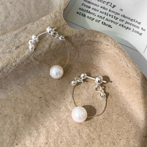 Boucles d'oreilles perles minimalistes avec perles argentées sur papier texturé