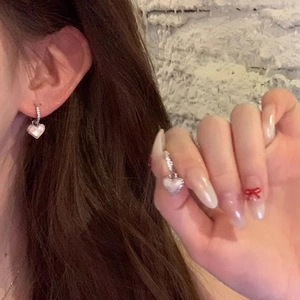 Eleganti orecchini a cuore in argento con intarsio in conchiglia bianca indossati