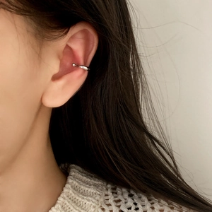 Ear cuff minimalista de plata en forma de C en metal pulido usado por una mujer real