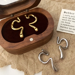 Earcuffs minimalistas con forma de serpiente en oro y plata sobre terciopelo fino