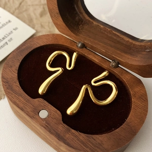 Pendientes dorados con diseño de serpiente en un joyero de madera de alta calidad