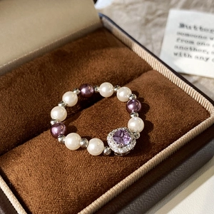 Detail of beaded pearl ring with square purple stone in a luxury velvet jewelry box