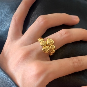Elegant gold stacked heart ring with high-polished finish on textured black background