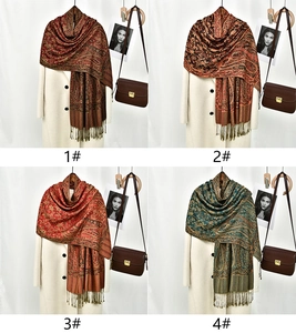 Detail view of four ethnic jacquard shawls with paisley patterns and elegant tassels