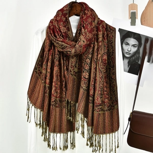 Detail of bohemian paisley jacquard shawl with long fringe tassels for winter warmth