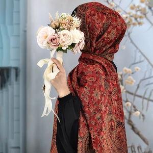 Detail of red and brown paisley pattern jacquard shawl with decorative fringe edges