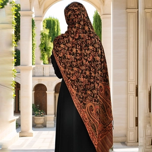 Close-up of ethnic paisley pattern detail on vintage shawl with tassels and fringe