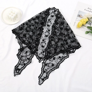 Elegant black lace headscarf with hollow floral patterns on white draped fabric