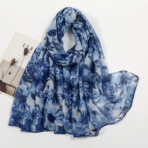 Detail of blue floral voile scarf featuring semi-transparent fabric and rolled hem edges