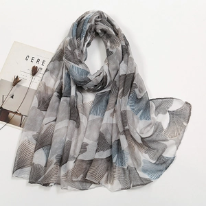Detail view of lightweight voile scarf featuring artistic blue ginkgo leaf prints