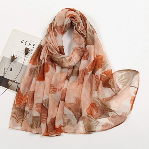 Detailed texture of lightweight orange and brown voile scarf with ginkgo leaf pattern