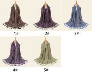 Detailed view of long paisley scarves with fringe tassels in five different colors