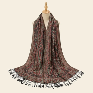 Ethnic paisley embroidered shawl scarf with fringe tassels on a wooden hanger