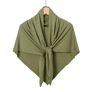 Detail of soft olive green mercerized cotton triangle shawl draped on a wooden hanger