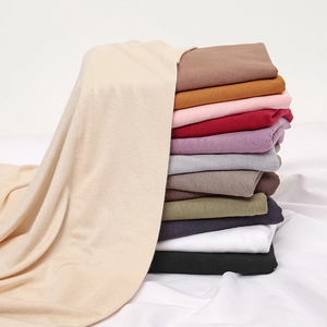 Stack of colorful mercerized cotton scarves in twelve solid shades for women