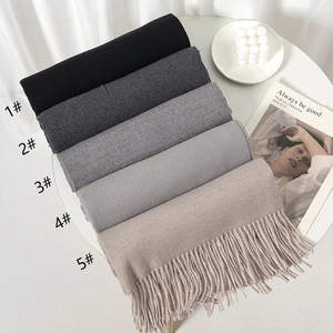 Close-up of soft cashmere-feel scarves in five neutral colors with long fringe details