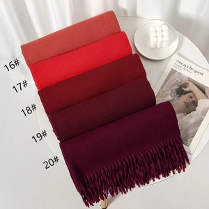 Close-up of five red gradient thick scarves with tassels and soft knit texture