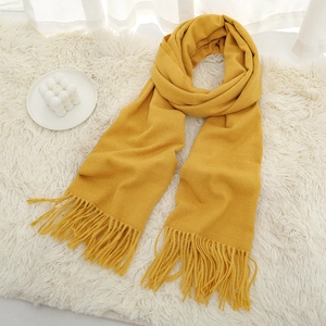 Detailed view of yellow cashmere-like scarf texture and delicate fringe tassels