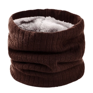 Détail macro du tour de cou en maille marron foncé avec doublure en peluche grise douce