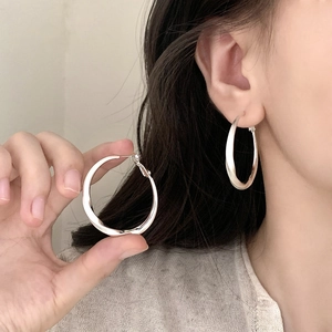 Minimalist silver twisted hoop earrings with brushed finish for a modern daily look
