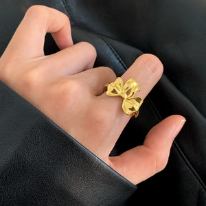 Elegante anello aperto a forma di fiocco dorato con dettagli di perline su pelle nera