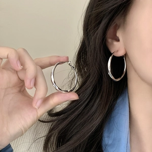 Minimalist silver twisted geometric hoop earrings with polished Mobius ring design