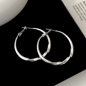 Detailed view of silver twisted hoop earrings with a polished Mobius design and pin closure