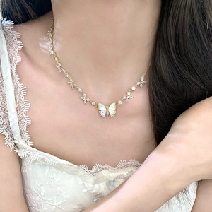 Collier papillon doré élégant avec incrustation de nacre et zircon porté par mannequin