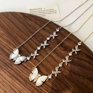Détail du collier papillon en nacre avec finitions or et argent et accents de zircon