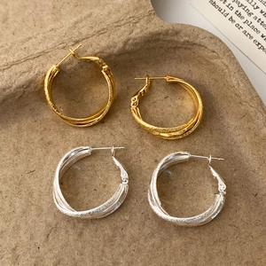 Matte geometric cross layered hoop earrings in gold and silver finishes, 45-degree view