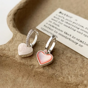 Vue détaillée des boucles d'oreilles cœur en émail rose et pierres de zircone brillantes